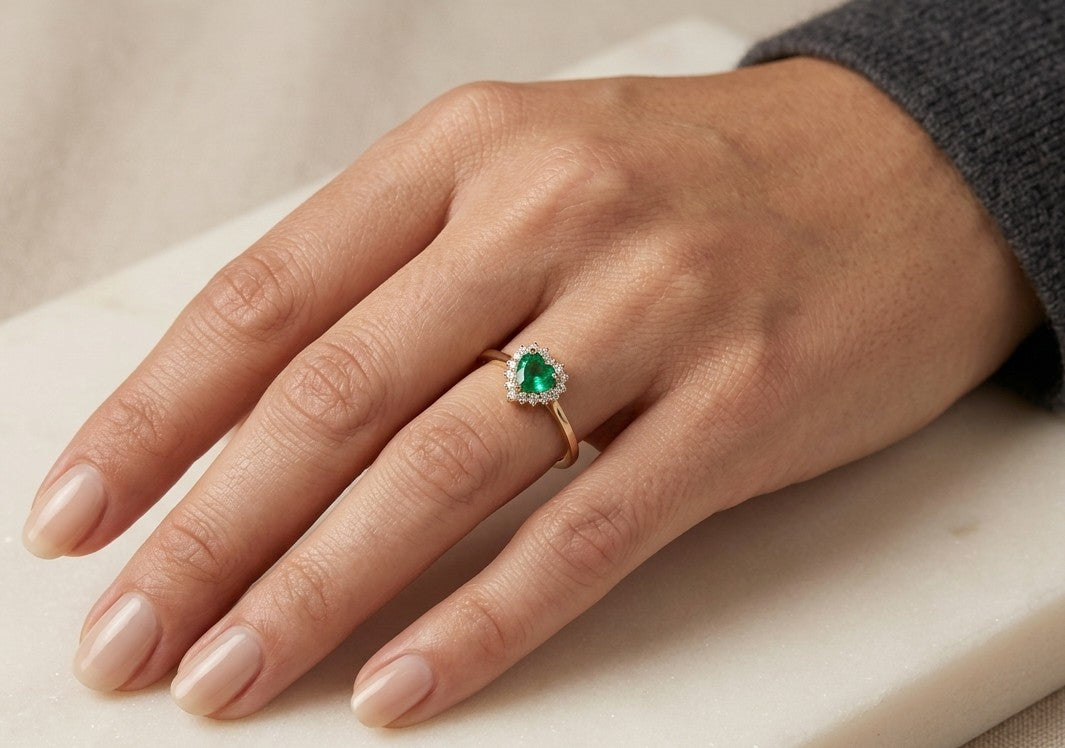Heart shaped emerald and diamond halo ring in 18K yellow gold with a slender polished band