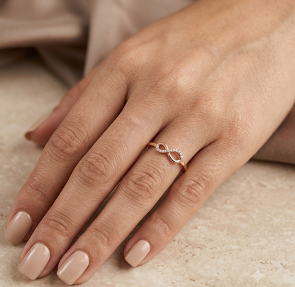 18K rose gold infinity diamond ring featuring natural round brilliant diamonds in a delicate symbolic design.