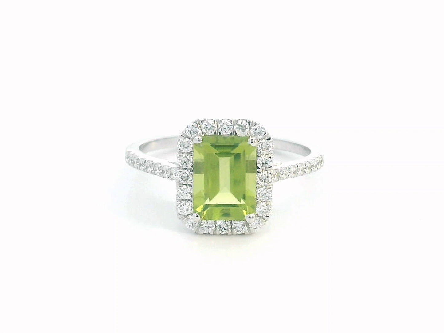 18K white gold emerald-cut Peridot ring with 0.35ct diamond halo, featuring 1.58ct Peridot centerpiece.