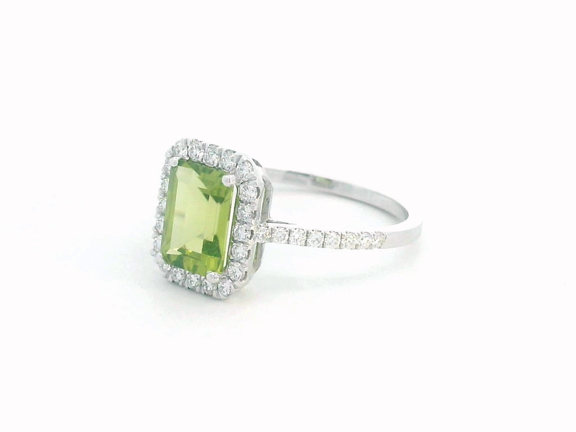 18K white gold emerald-cut Peridot ring with 0.35ct diamond halo, featuring 1.58ct Peridot centerpiece.