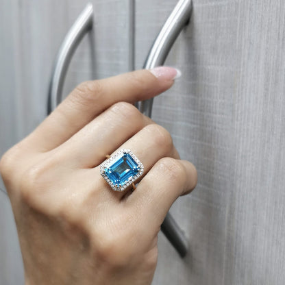 Elegant 7.62-carat emerald-cut Swiss Blue Topaz ring with a diamond halo, crafted in 18K White Gold – luxury cocktail ring