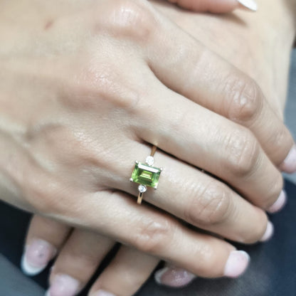 18K gold emerald-cut Peridot ring with 0.07ct diamond accents, featuring a vibrant 1.53ct Peridot centerpiece.