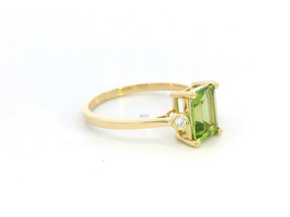 18K gold emerald-cut Peridot ring with 0.07ct diamond accents, featuring a vibrant 1.53ct Peridot centerpiece.