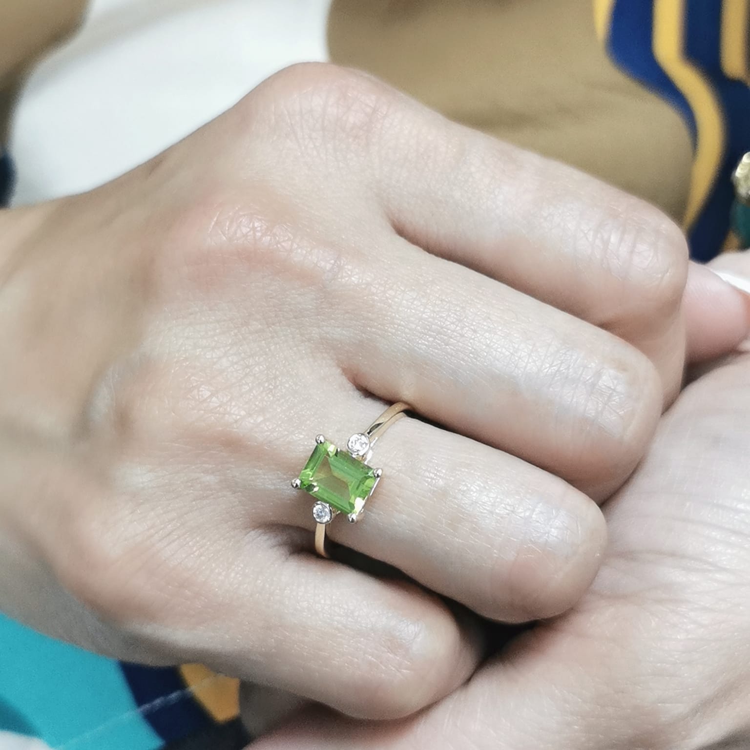 18K gold emerald-cut Peridot ring with 0.07ct diamond accents, featuring a vibrant 1.53ct Peridot centerpiece.