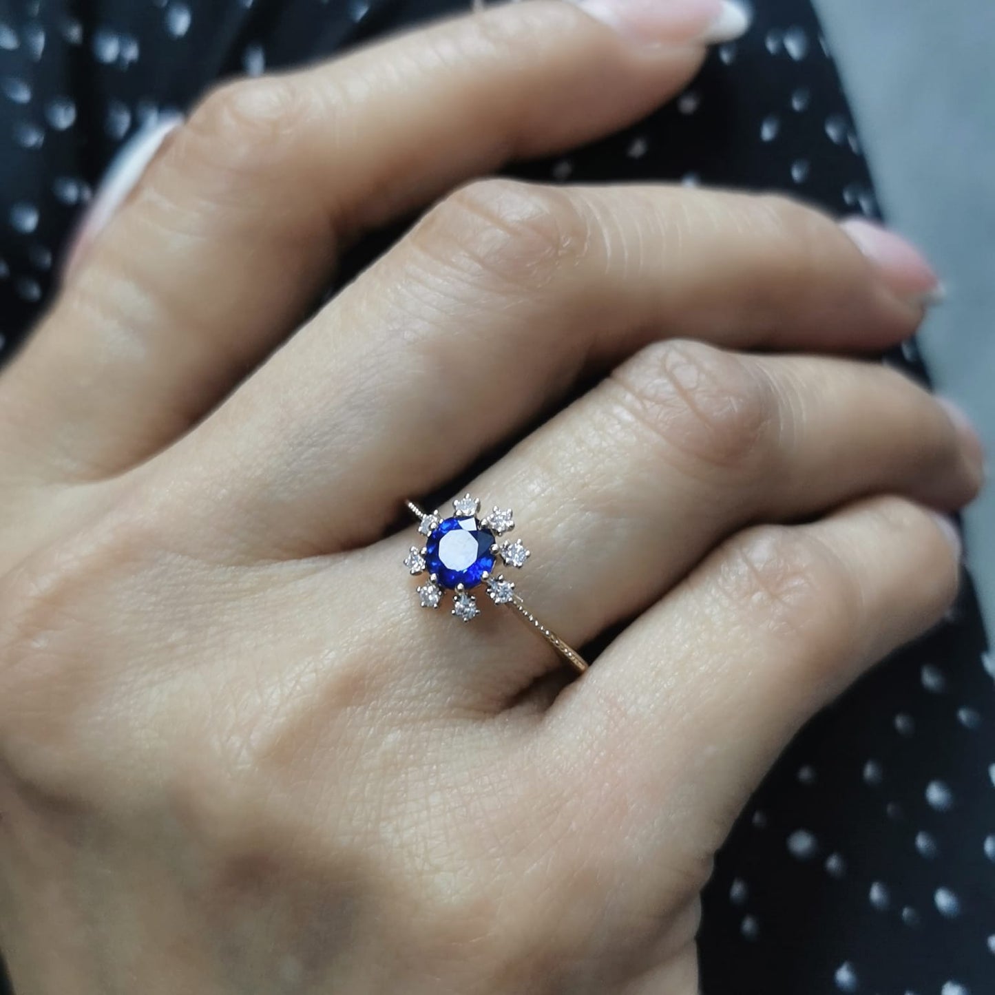 18K gold sapphire and diamond sunburst ring featuring a 0.79 CT royal blue sapphire with 0.15 CT diamonds in a floral-inspired setting.