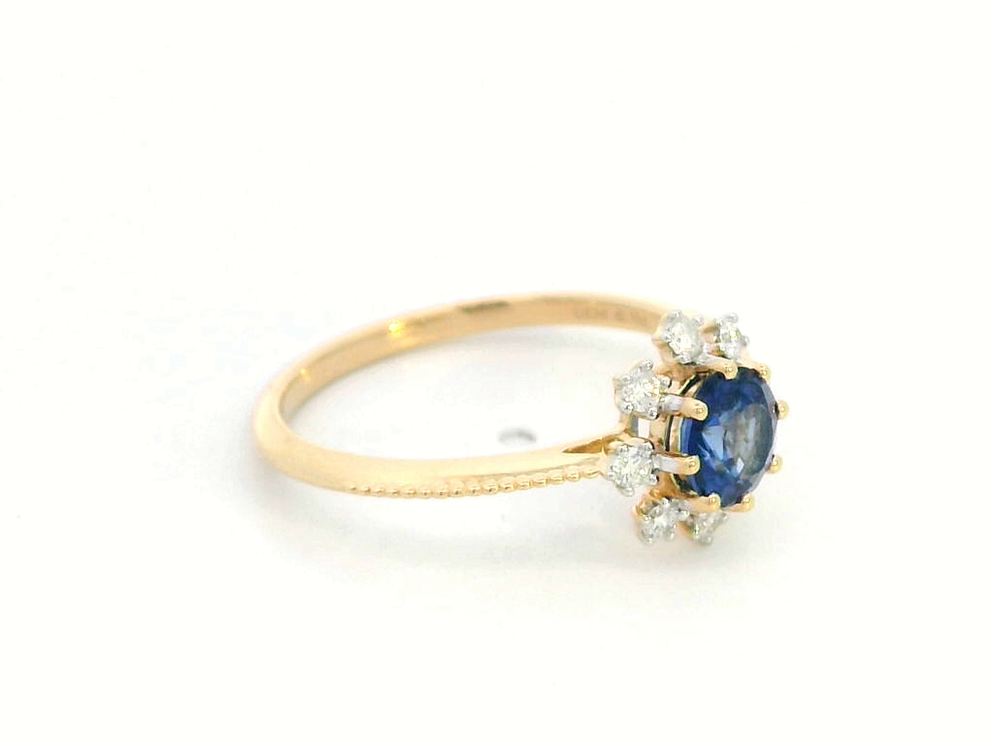 18K gold sapphire and diamond sunburst ring featuring a 0.79 CT royal blue sapphire with 0.15 CT diamonds in a floral-inspired setting.