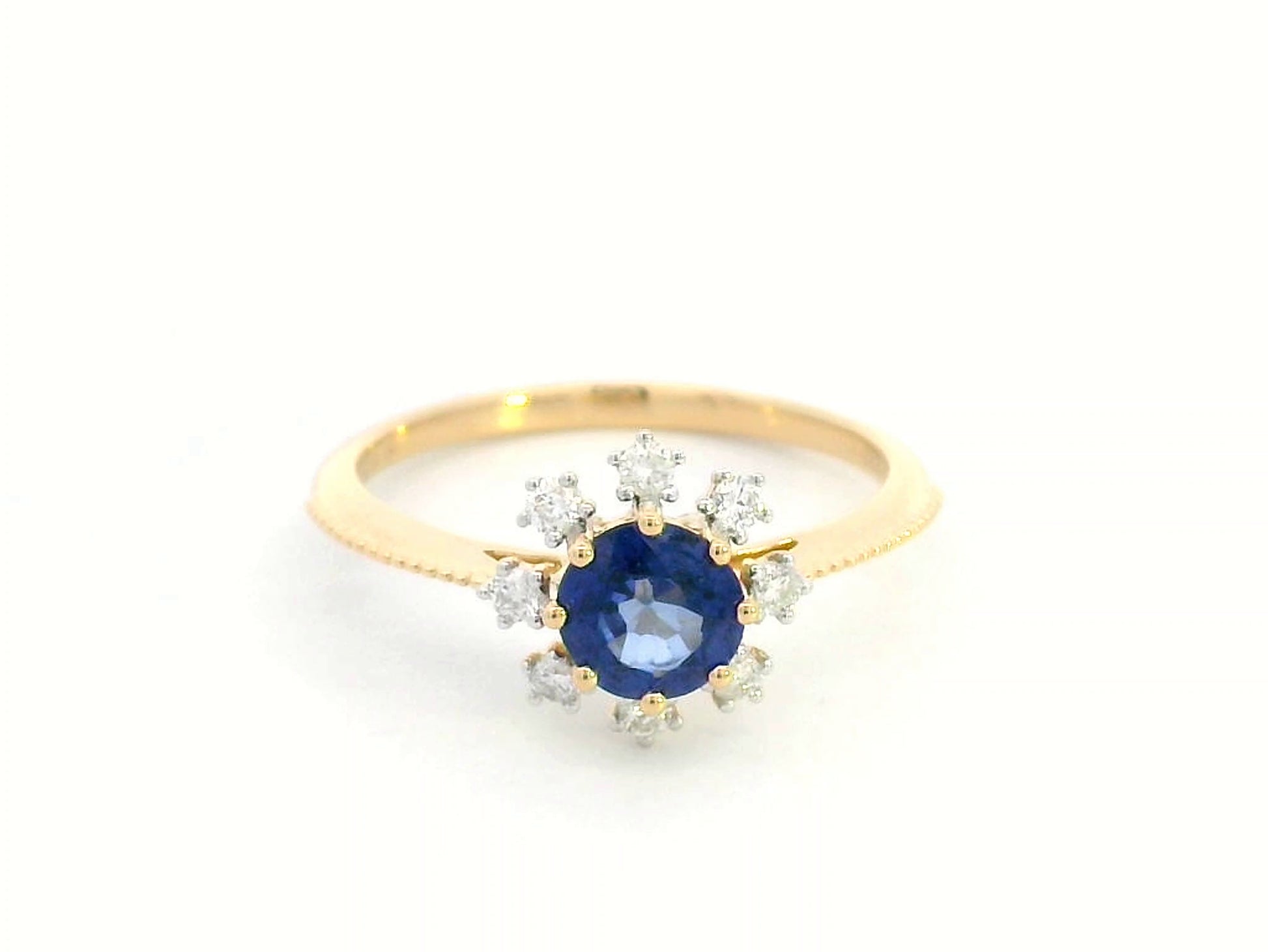 18K gold sapphire and diamond sunburst ring featuring a 0.79 CT royal blue sapphire with 0.15 CT diamonds in a floral-inspired setting.