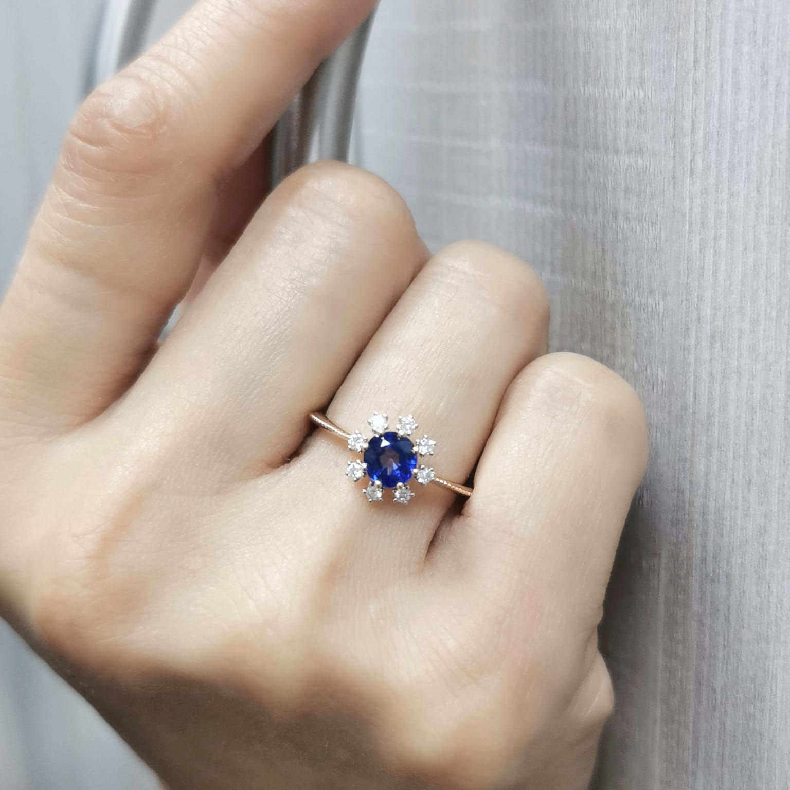 18K gold sapphire and diamond sunburst ring featuring a 0.79 CT royal blue sapphire with 0.15 CT diamonds in a floral-inspired setting.