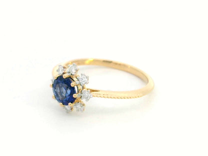 18K gold sapphire and diamond sunburst ring featuring a 0.79 CT royal blue sapphire with 0.15 CT diamonds in a floral-inspired setting.