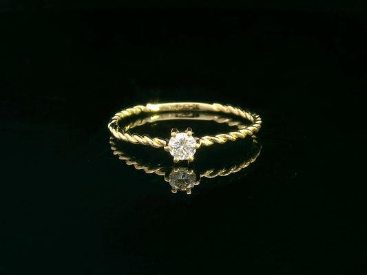 18K yellow gold twisted band diamond ring featuring a 0.15-carat round solitaire diamond in a delicate rope-style design