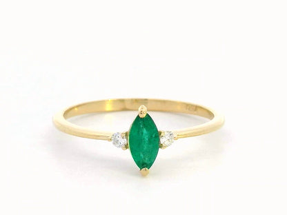 Elegant 18K gold marquise-cut emerald and diamond ring featuring a 0.21-carat emerald and 0.03-carat diamond accents.