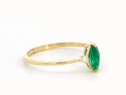 Elegant 18K gold marquise-cut emerald and diamond ring featuring a 0.21-carat emerald and 0.03-carat diamond accents.