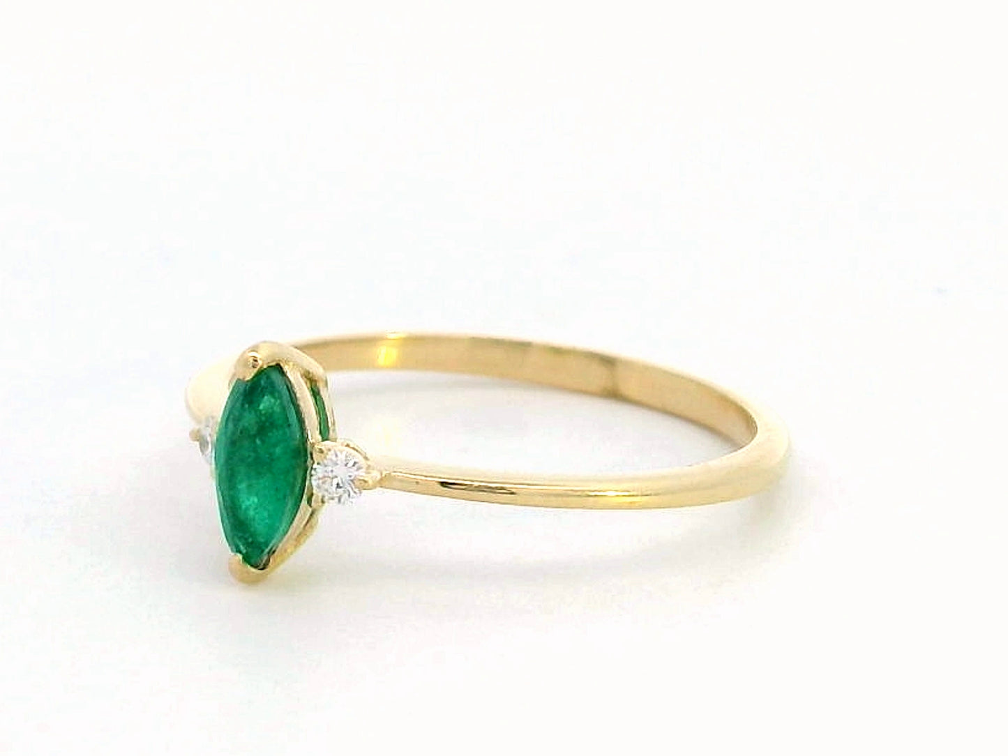 Elegant 18K gold marquise-cut emerald and diamond ring featuring a 0.21-carat emerald and 0.03-carat diamond accents.