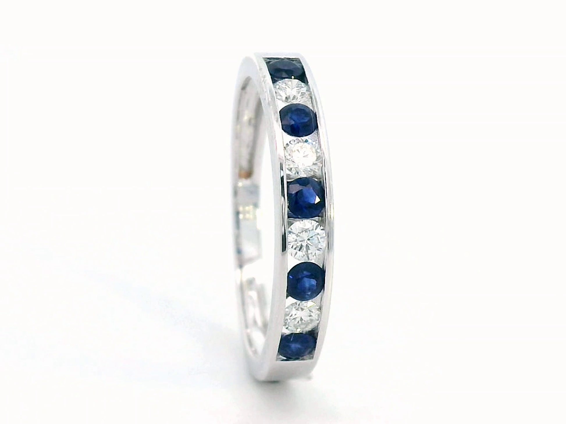 18K gold channel-set sapphire and diamond ring featuring 0.69-carat blue sapphires and 0.43-carat brilliant diamonds in a timeless eternity band design