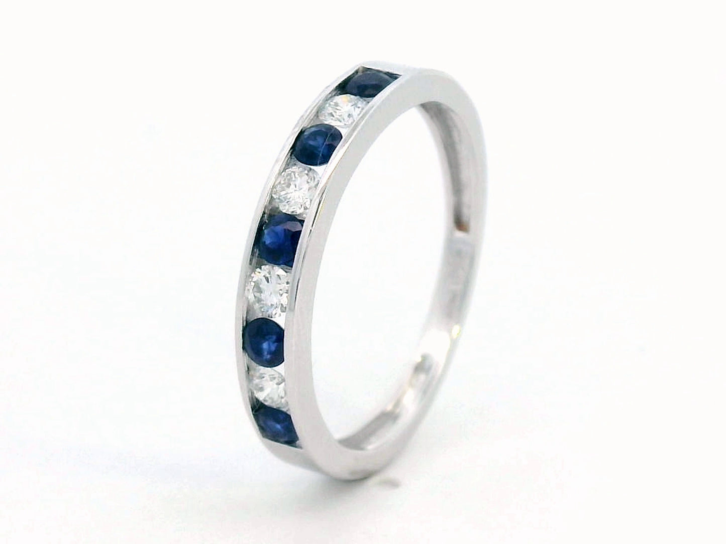 18K gold channel-set sapphire and diamond ring featuring 0.69-carat blue sapphires and 0.43-carat brilliant diamonds in a timeless eternity band design