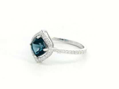 Cushion-cut London Blue Topaz ring with diamond halo and pavé diamond band in 18K gold

