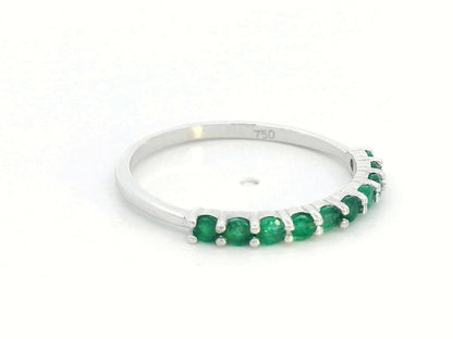 18K gold half-eternity ring with 0.42 carat round-cut emeralds in a prong setting.