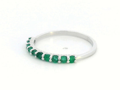 18K gold half-eternity ring with 0.42 carat round-cut emeralds in a prong setting.