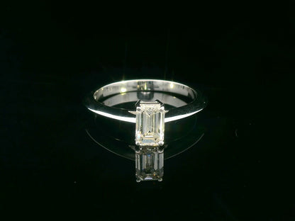 0.91 carat emerald cut diamond solitaire ring with knife-edge 18K gold band, minimalist and elegant design.