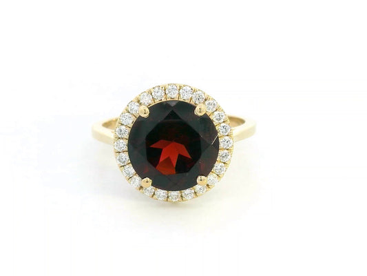 Round garnet and diamond halo ring in 18K yellow gold featuring a 3.85 carat garnet and 0.27 carats of diamonds.