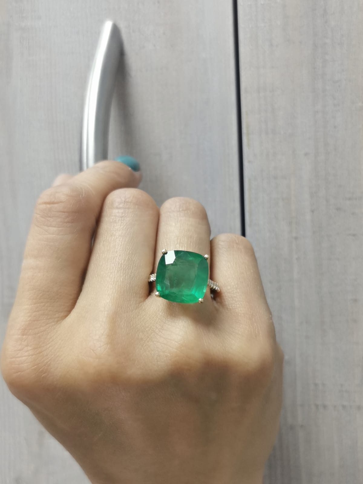 9.01 carat cushion-cut emerald ring in 18K yellow gold with hidden halo and diamond pavé band