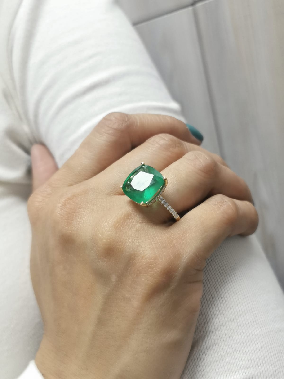9.01 carat cushion-cut emerald ring in 18K yellow gold with hidden halo and diamond pavé band