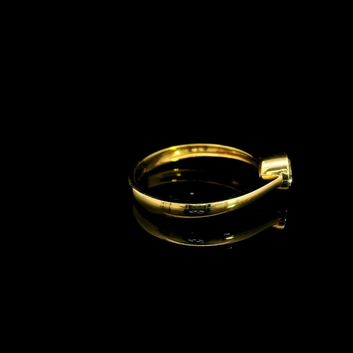 Round brilliant bezel set diamond engagement ring in 18K yellow gold with a slender solitaire band.