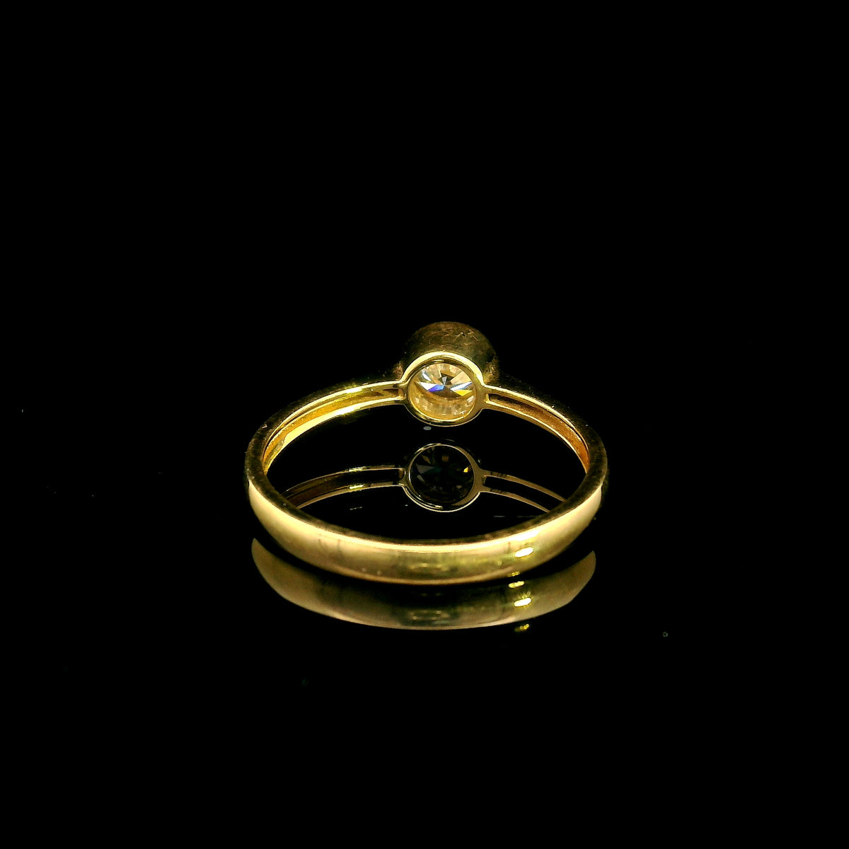 Round brilliant bezel set diamond engagement ring in 18K yellow gold with a slender solitaire band.