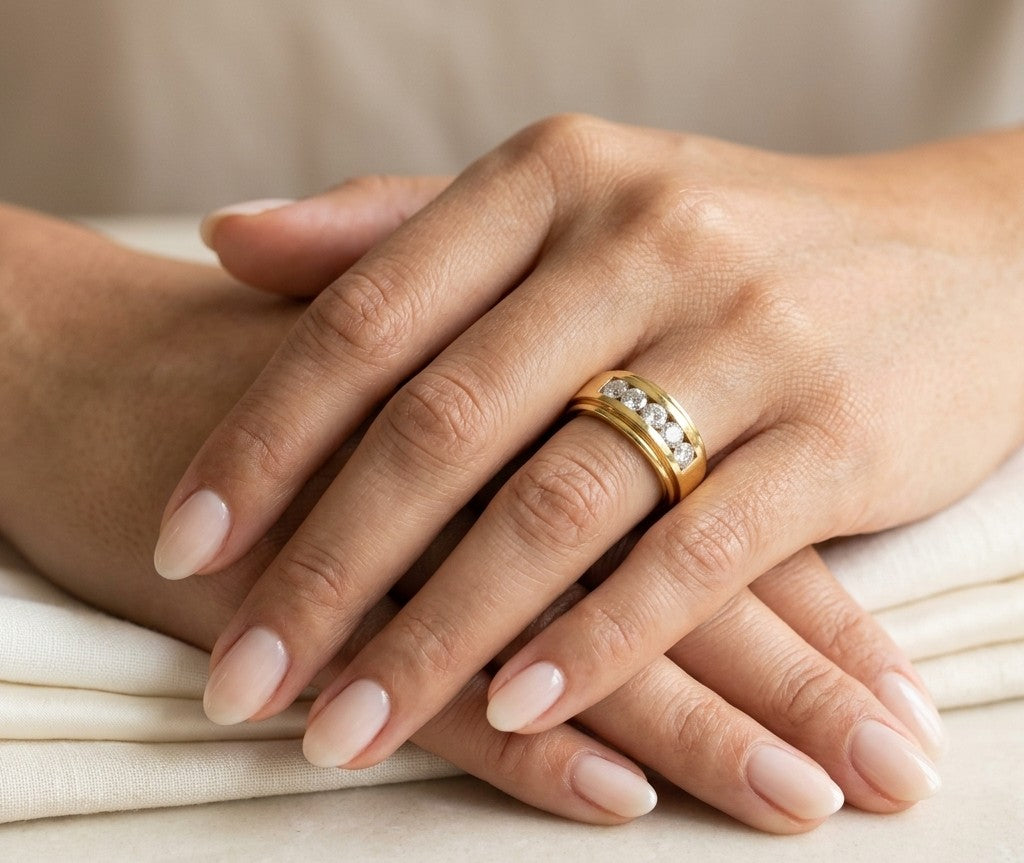 Yellow gold diamond band ring with channel set round diamonds and broad polished gold edges