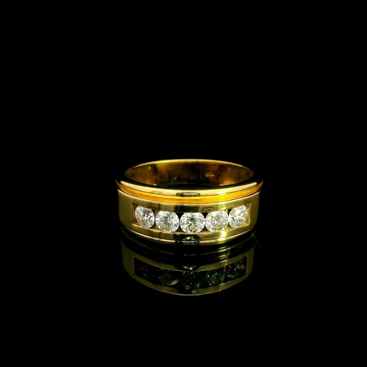 Yellow gold diamond band ring with channel set round diamonds and broad polished gold edges