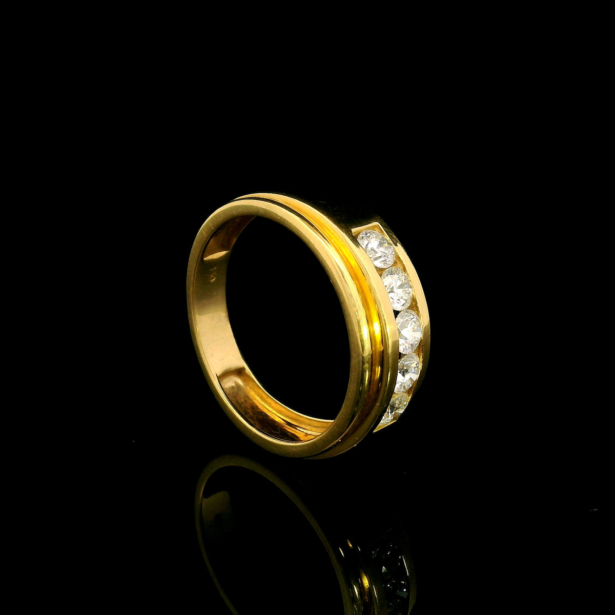 Yellow gold diamond band ring with channel set round diamonds and broad polished gold edges