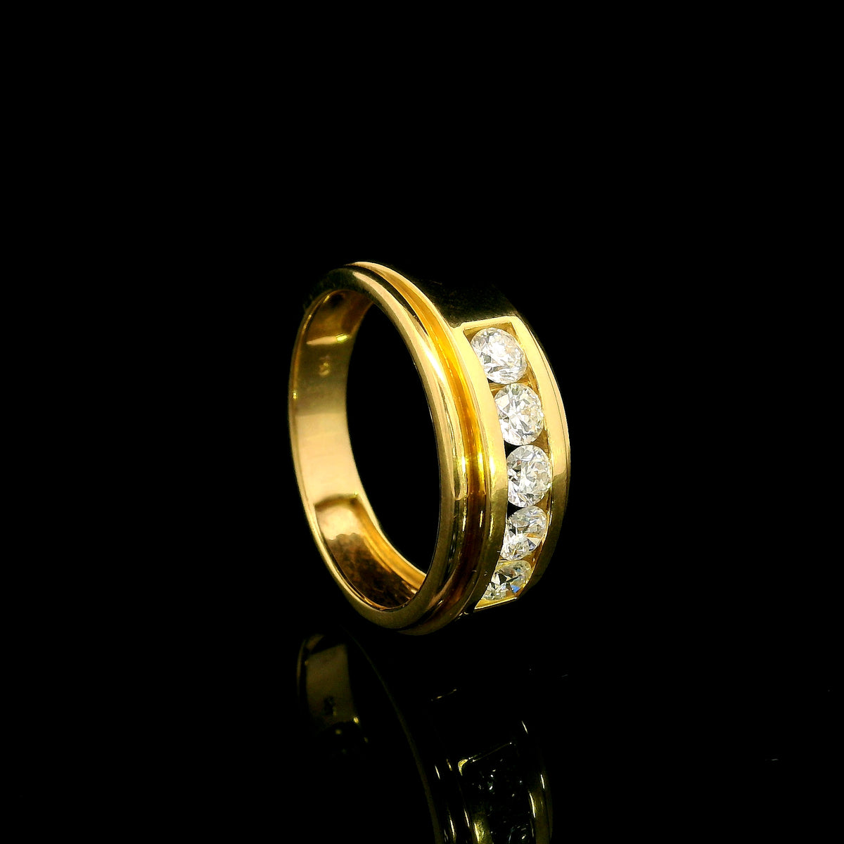 Yellow gold diamond band ring with channel set round diamonds and broad polished gold edges