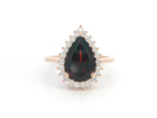 18K rose gold ring with pear-shaped garnet and starburst diamond halo setting