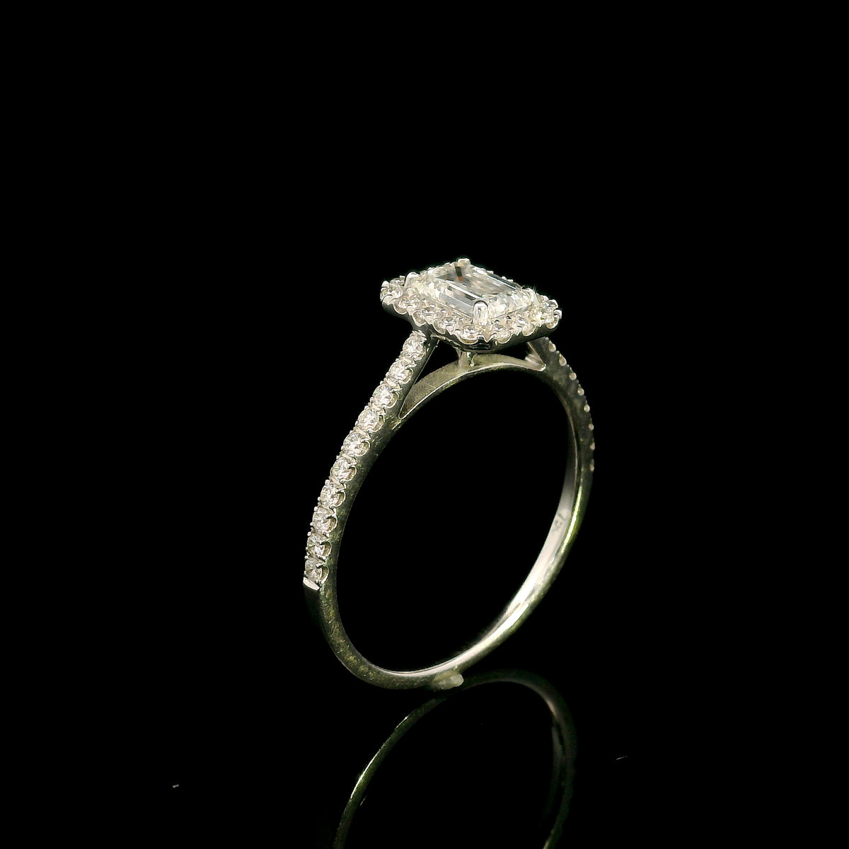 Emerald cut diamond halo bridal set in 18K white gold with a diamond engagement ring and matching wedding band.