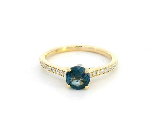 18K yellow gold ring with 0.93 carat round Blue Topaz center and 0.20 carat round diamond accents in fine prong setting along the band


