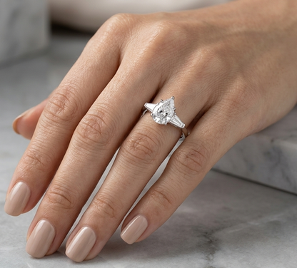 Natural 2.01 carat GIA certified pear-shaped diamond engagement ring in solid 18K white gold with 0.61 carats of tapered baguette side diamonds in a classic three-stone setting.