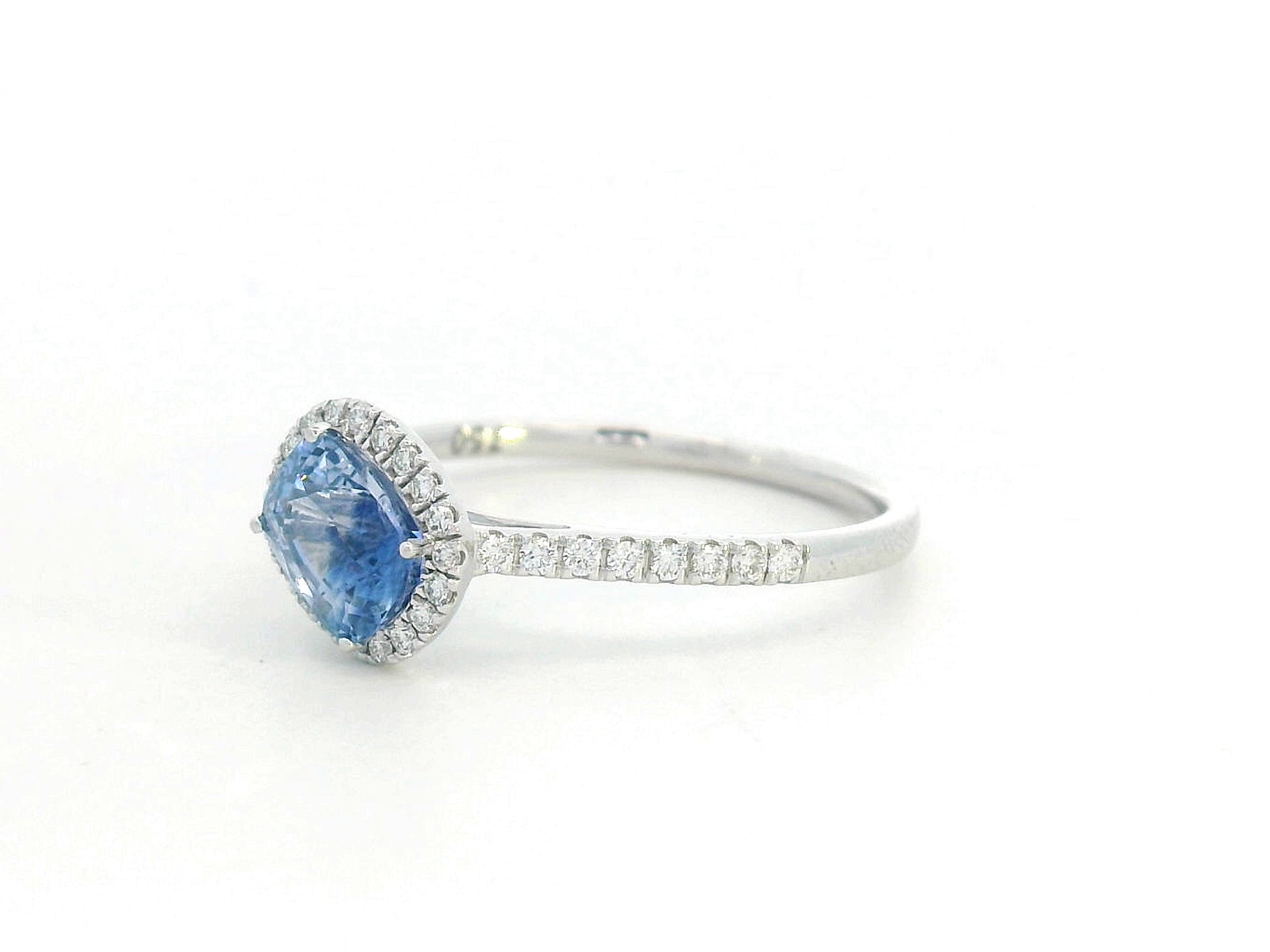 Ring with a blue gemstone and diamond accents on a white background