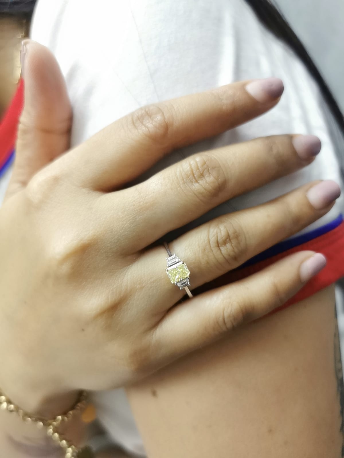 18K white gold ring with radiant-cut Fancy Yellow Diamond and trapezoid-cut side diamonds