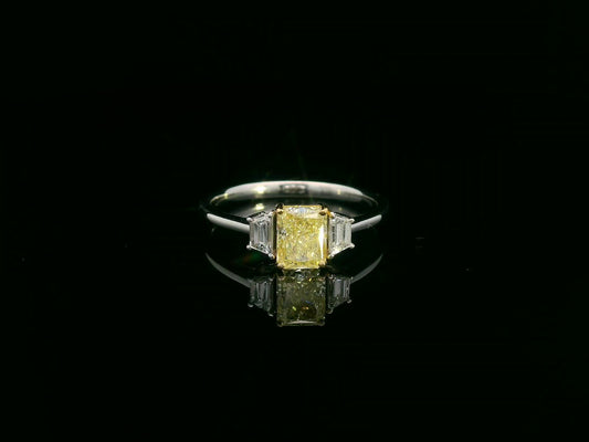 18K white gold ring with radiant-cut Fancy Yellow Diamond and trapezoid-cut side diamonds