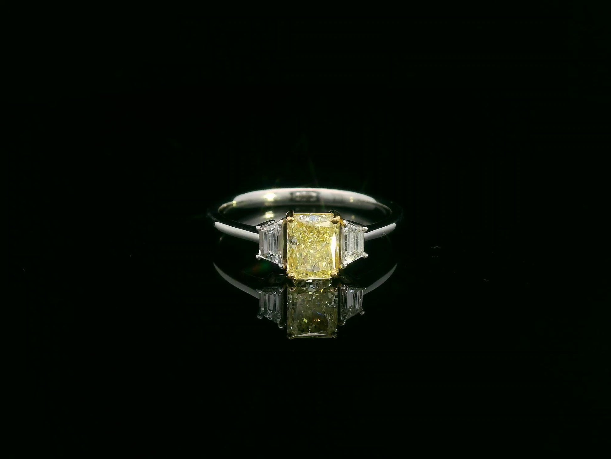 18K white gold ring with radiant-cut Fancy Yellow Diamond and trapezoid-cut side diamonds