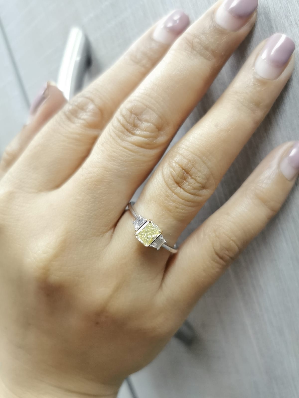 18K white gold ring with radiant-cut Fancy Yellow Diamond and trapezoid-cut side diamonds