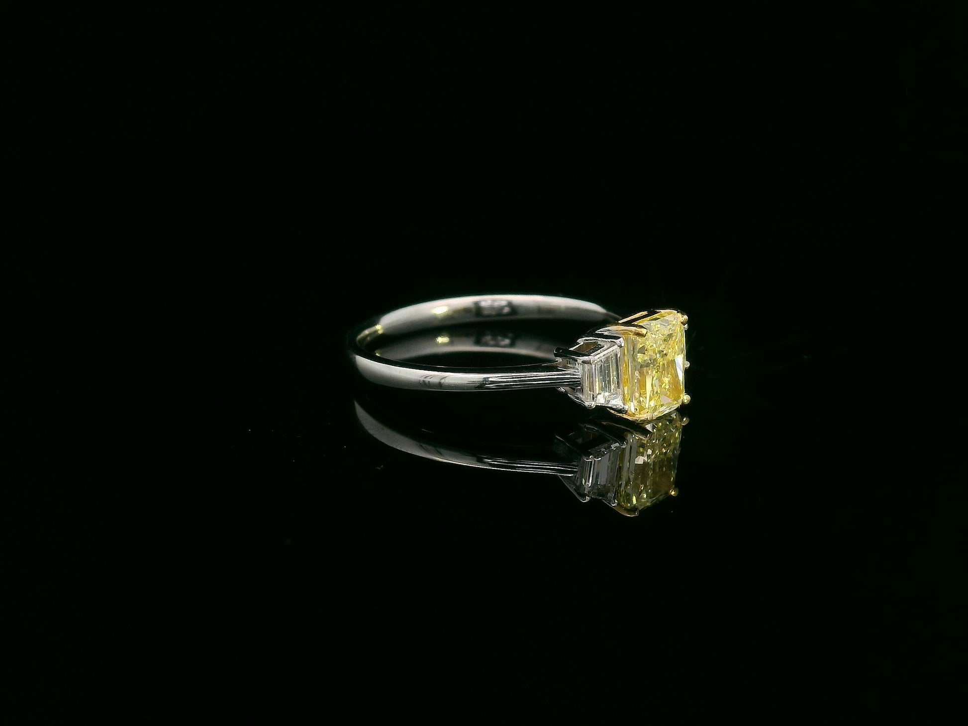 18K white gold ring with radiant-cut Fancy Yellow Diamond and trapezoid-cut side diamonds