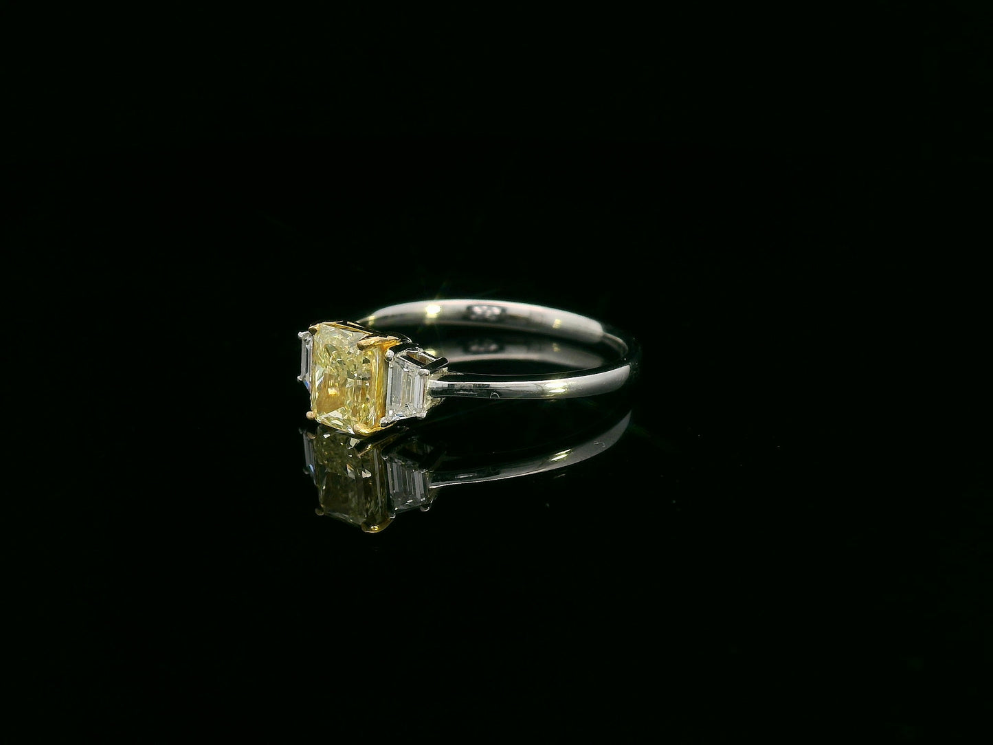 18K white gold ring with radiant-cut Fancy Yellow Diamond and trapezoid-cut side diamonds