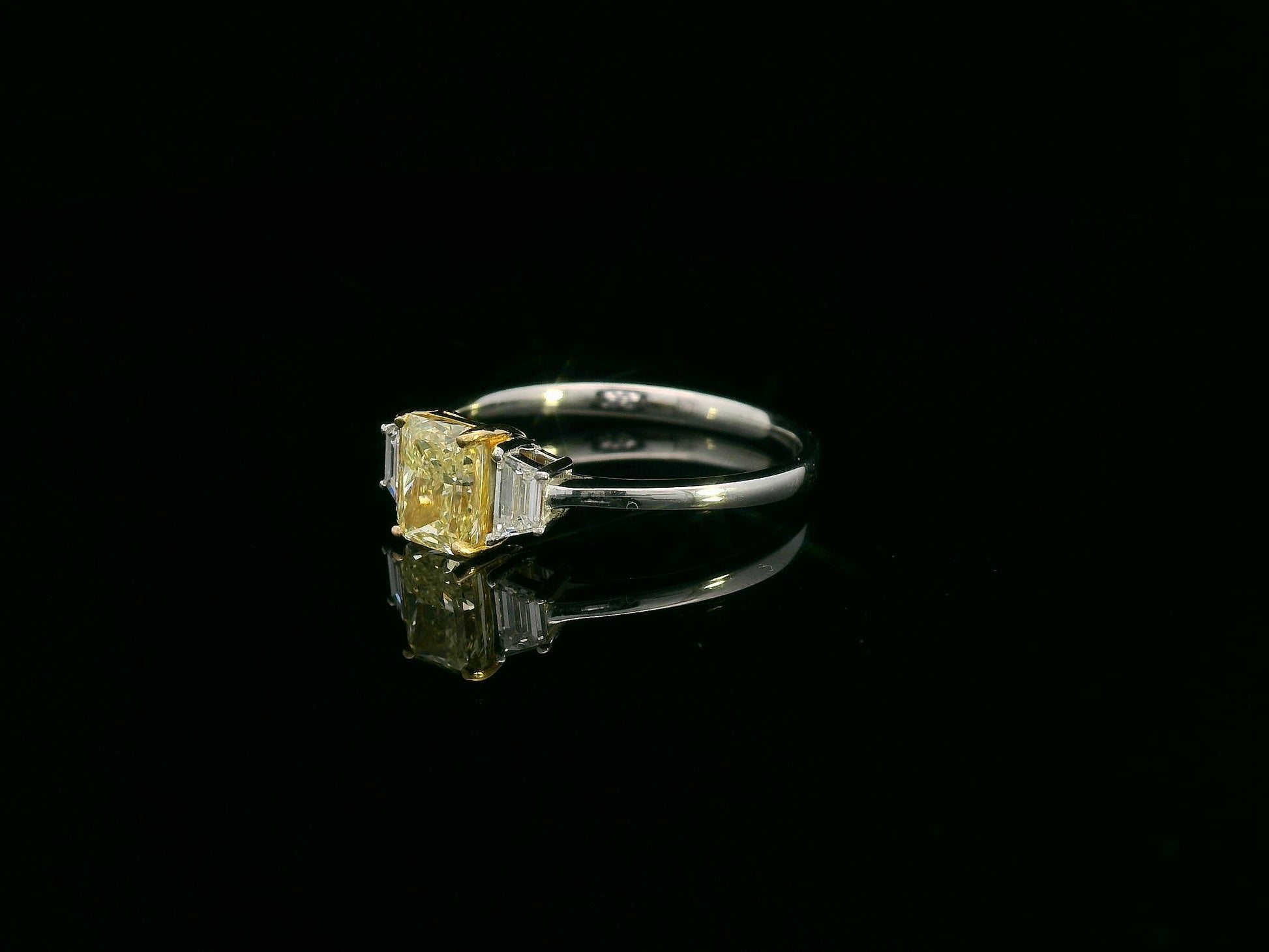 18K white gold ring with radiant-cut Fancy Yellow Diamond and trapezoid-cut side diamonds