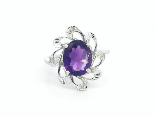 white gold  ring with a purple gemstone on a white background