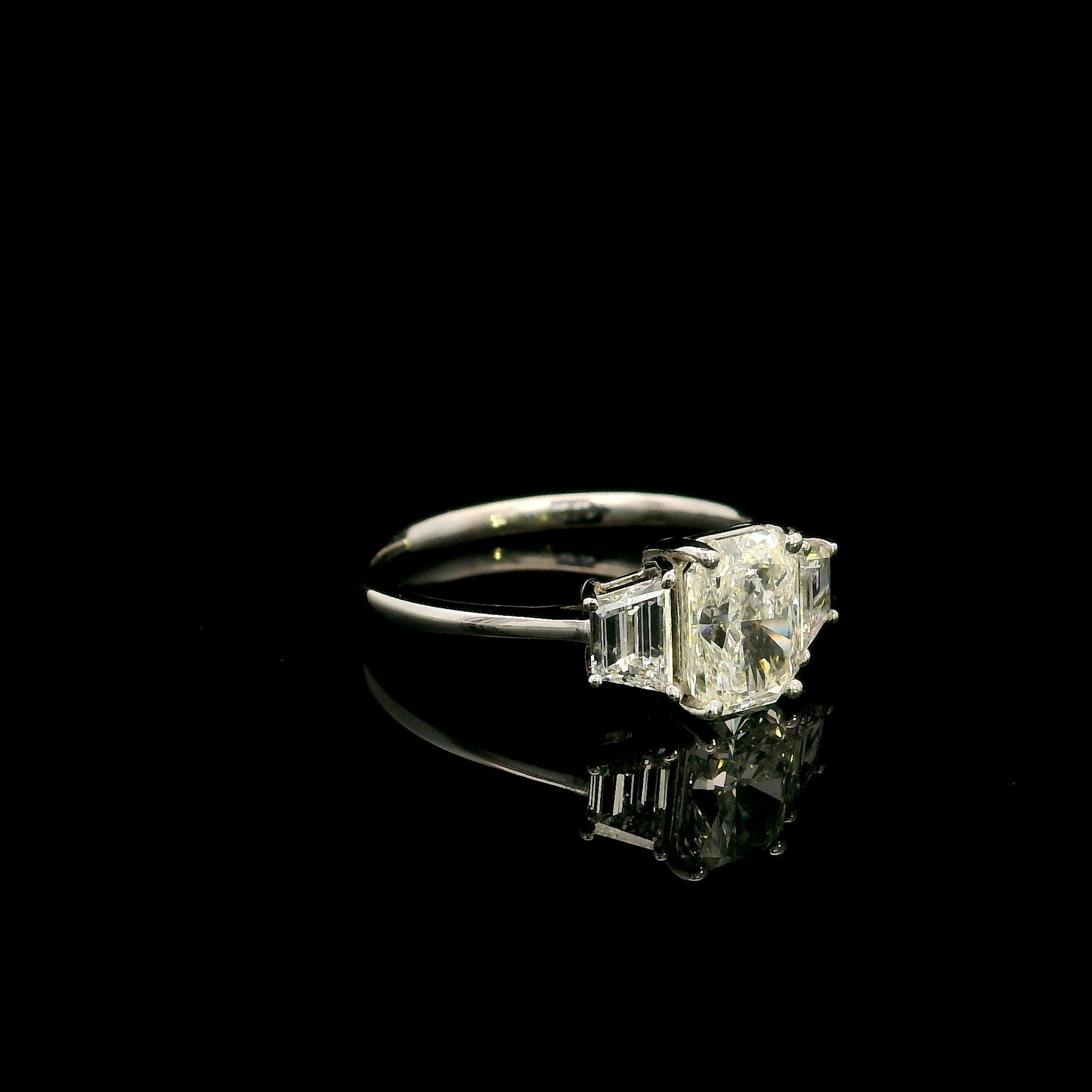 18K white gold radiant cut diamond engagement ring with a 1.51 carat HRD certified centre diamond and trapezoid side diamonds.