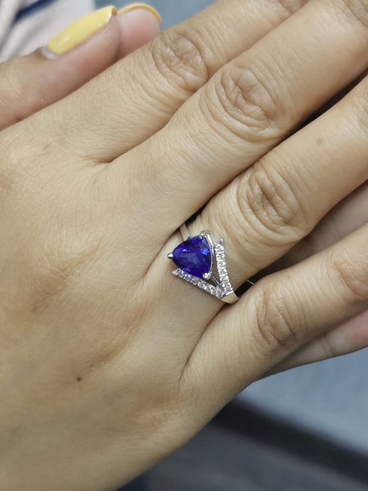 On-person view highlighting the deep blue trillion-cut tanzanite