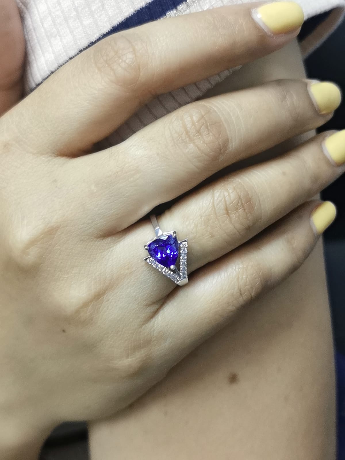 On-person view highlighting the deep blue trillion-cut tanzanite