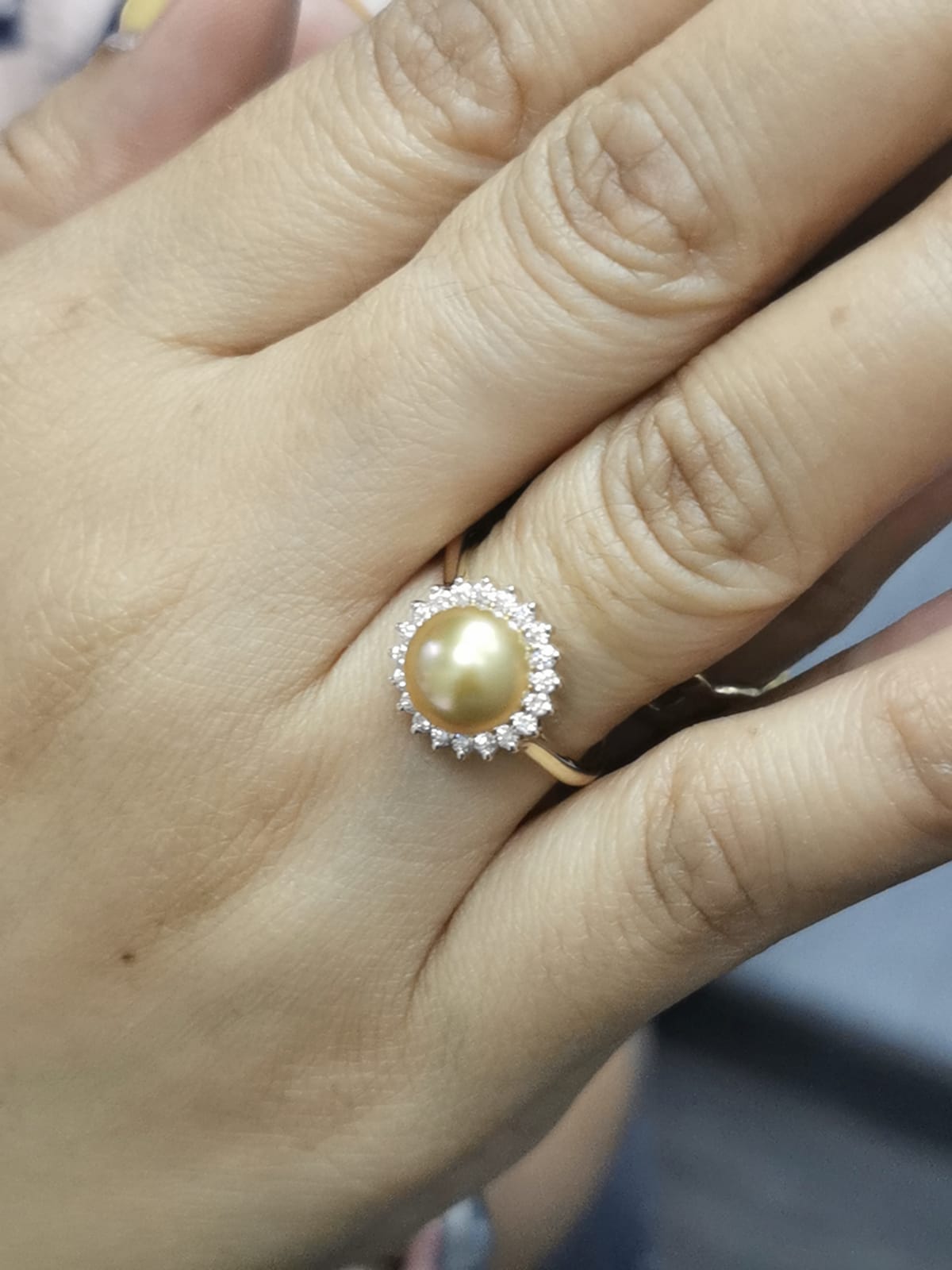 Ring on finger showcasing opulent pearl and diamond combination