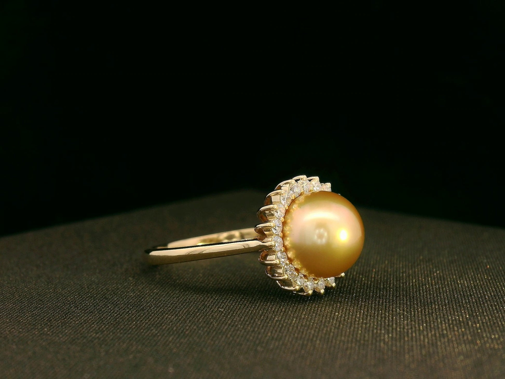 Side view highlighting pearl centerpiece and sparkling diamond halo